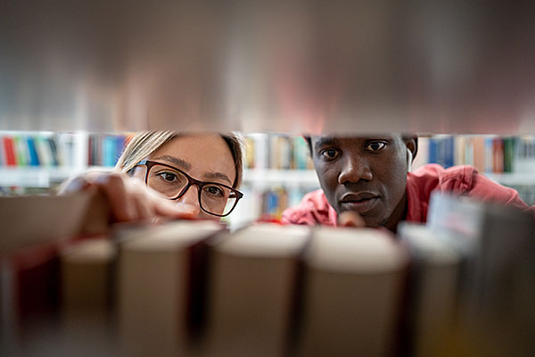 looking at books in library stacks