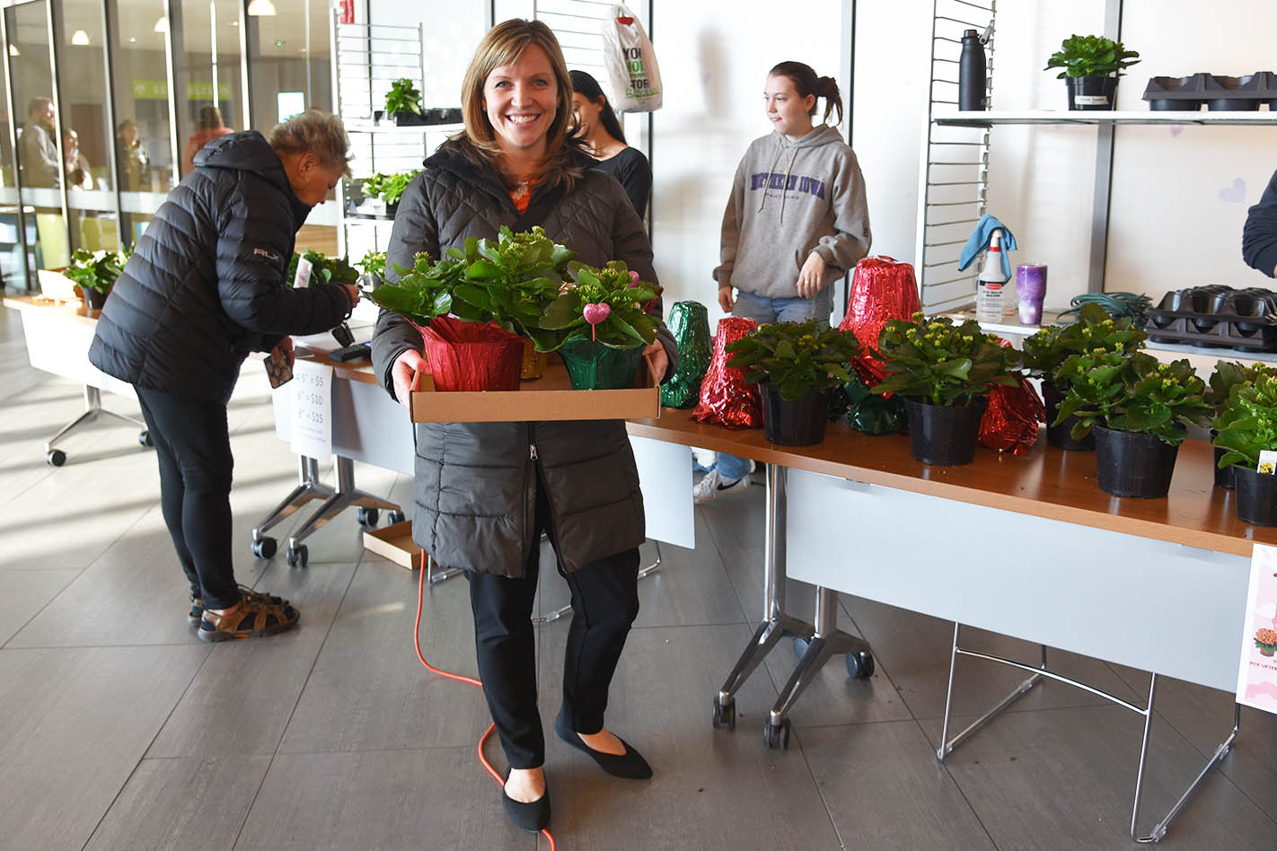 Megan Snook-Lautner (above, foreground), Assistant Director of Student Development at DMACC, pauses for a quick photo after picking up her order of kalanchoe plants during the first day of the DMACC Horticulture Club's Valentine's Day Sale on Tues., Feb. 13, at the Ankeny Campus. 