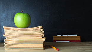 A stack of books with an apple on top